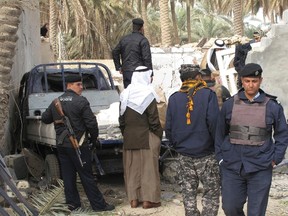 Policemen gather at the site of a bomb blast in Mussayab, about 60 km (40 miles) south of Baghdad January 26, 2012. (REUTERS/Habib)