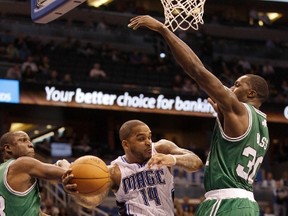 Orlando Magic guard Jameer Nelson (C) pitches out around Boston Celtics guard Mickael Pietrus (L) and forward Brandon Bass (R) during the second half of their NBA basketball game in Orlando January 26, 2012. (REUTERS/Kevin Kolczynski)
