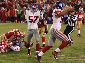The Giants' Spencer Paysinger (right) and Jacquian Williams (57) celebrate Devin Thomas' (15) fumble recovery during fourth quarter NFC Championship action in San Francisco on Sunday, Jan. 22, 2012. (REUTERS/Jeff Haynes)