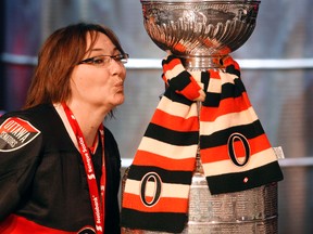 Mary-Anne Berube shows her Senators team spirit while posing with the Stanley Cup during the Scotiabank NHL Fan Fair at the Ottawa Convention Centre in January. (DARREN BROWN/QMI AGENCY)