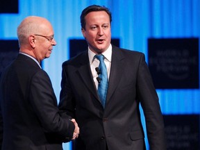 Britain's Prime Minister David Cameron (R) shakes hands with Klaus Schwab, Founder and Executive Chairman, World Economic Forum, during a session at the World Economic Forum (WEF) in Davos, January 26, 2012. (REUTERS/Arnd Wiegmann)
