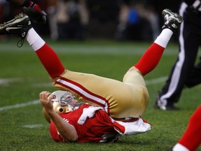 San Francisco 49ers quarterback Alex Smith is knocked to the field after throwing a pass against the New York Giants during the second quarter of the NFL's NFC Championship game in San Francisco, California, Jan. 22, 2012. (REUTERS/Jeff Haynes)