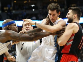 Denver Nuggets’ Al Harrington (left) purposely shoves teammate Rudy Fernandez into the Raptors’ Linas Kleiza during a skirmish in Denver on Friday night. (Reuters)