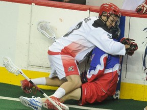 Roughnecks’ Dan MacRae (left) roughs up the Rock’s Dan Carey at the Scotiabank Saddledome in Calgary last night. (STUART DRYDEN/qmi agency)