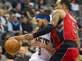 Raptors guard Jerryd Bayless (5) fouls New Jersey Nets guard Deron Williams (8) in the second quarter of their NBA basketball game in Newark, New Jersey, January 29, 2012. (Ray Stubblebine/Reuters)