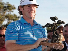Brandt Snedeker holds up his trophy on the 18th green after winning the Farmers Open in San Diego on Sunday, Jan. 29, 2012. (REUTERS/Denis Poroy)