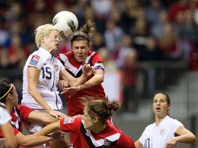 USA's Magan Rapinoe (left) heads the ball against Canada's Christine Sinclair during the CONCACAF women's Olympic qualifying soccer tournament final in Vancouver, B.C., Jan. 29, 2012. (BEN NELMS/Reuters)