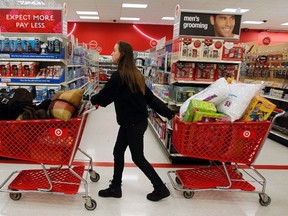 A woman pulls shopping carts through the aisle of a Target store on the shopping day dubbed "Black Friday" in Torrington, Conn. Nov. 25, 2011. REUTERS/Jessica Rinaldi