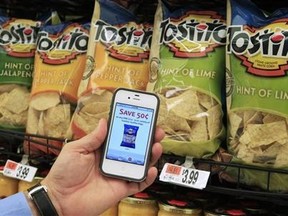 A customer with the Scan It! Mobile app on his iPhone shows a coupon for Tostitos chips while shopping at Stop and Shop supermarket in Braintree, Massachusetts. (Reuters/Adam Hunger)