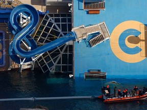 Coast Guard divers return to their boat alongside the cruise liner Costa Concordia off the west coast of Italy at Giglio island January 30, 2012.  REUTERS/Darrin Zammit Lupi