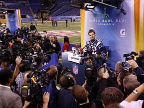 New England Patriots' QB Tom Brady is surrounded by reporters and camera's during Tuesday's media day in Indianapolis. (REUTERS)