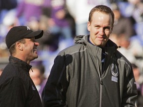 Baltimore Ravens head coach John Harbaugh  shares a laugh with injured Indianapolis Colts quarterback Peyton Manning before a game in December. (REUTERS)