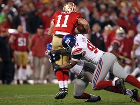 San Francisco 49ers quarterback Alex Smith is sacked by New York Giants defensive end Jason Pierre-Paul (left) and defensive end Justin Tuck  during the third quarter of Sunday's NFC Championship. (REUTERS)