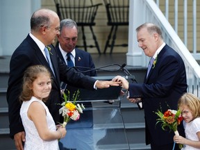 Jonathan Mintz (2nd L), New York City's consumer affairs commissioner, has a wedding ring placed on his finger by John Feinblatt (R), a chief adviser to the mayor, as they stand with daughters Maeve (L) and Georgia during a marriage ceremony presided by New York City Mayor Michael Bloomberg (C) at Gracie Mansion in New York July 24, 2011. (REUTERS/Lucas Jackson)
