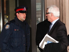 Toronto Police Const. Michael Adams talks to his lawyer, Gary Clewley. (CHRIS DOUCETTE, Toronto Sun)