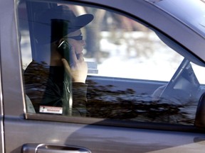 A motorist talks on a cellphone while driving near 124 Street and Jasper Avenue in Edmonton Wednesday. (TOM BRAID/Edmonton Sun)