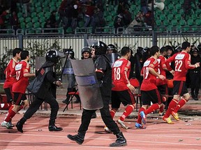 Riot police guard Al Ahli soccer players as they flee Port Said Stadium in Egypt on Wednesday, Feb. 1, 2012. (REUTERS/Stringer)