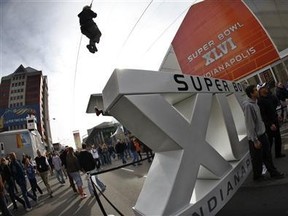 A fan rides on a zip line in downtown Indianapolis, Indiana February 3, 2012, ahead of the NFL's Super Bowl XLVI football game. Credit: Reuters/Mike Segar