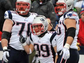 New England Patriots guard Logan Mankins (left) celebrates a touchdown with running back Danny Woodhead (centre) and offensive lineman Sebastian Vollmer during their Boxing Day win in Buffalo. (REUTERS)