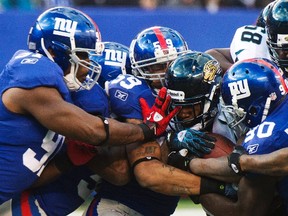 New York Giants defensive end Justin Tuck (left), linebacker Michael Boley (59) and defensive end Jason Pierre-Paul (right) gang tackle Jacksonville Jaguars running back Maurice Jones-Drew during a game in November. (REUTERS)