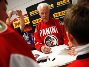 NHL hockey legend, Gordie Howe, center signs autographs for John Viau, left and his son, Migel, right during the Scotiabank NHL Fan Fair at the Ottawa Convention Centre. (DARREN BROWN/QMI Agency)