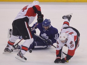 Leafs forward Matthew Lombardi tries to handle the pick after being knocked down by the the Senators’ Colin Greening (left) and Jason Spezza last night.