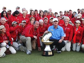 Paul Lawrie of Scotland poses for a picture with volunteers after winning the Qatar Masters golf tournament in Doha February 5, 2012. REUTERS/Fadi Al-Assaad