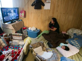 Lee Kamalatisit and her two-month-old daughter Kaylee sit in their unserviced one room home in Atawapiskat, Ontario, December 17, 2011.   REUTERS/Frank Gunn