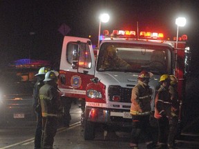 Shakespeare firefighters, who were among the first on the scene of a horrific fatal crash, just northeast of Stratford, Ont., view the work of investigators in the hamlet of Hampstead on Monday, Feb. 6, 2012. (SCOTT WISHART/QMI AGENCY)