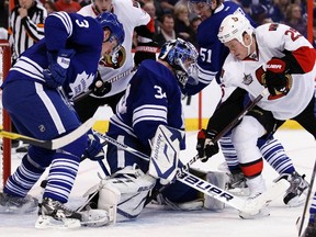 Senators forward Chris Neil (right) tries to jam a puck past  Maple Leafs goalie James Reimer and captain Dion Phaneuf Saturday night in Ottawa. (Reuters)