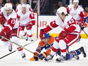 Corey Potter loses the puck to Detroit Red Wings Pavel Datsyuk, left, and Darren Helm during the first period at Rexall Place on Saturday.