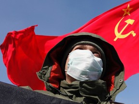 A demonstrator stands in front of a soviet flag during a protest demanding fair elections in the southern Russian city of Stavropol Feb. 4, 2012.  REUTERS/Eduard Korniyenko