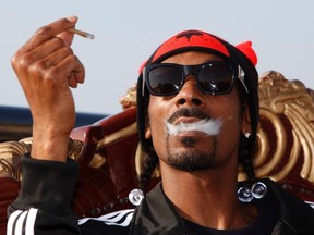 U.S. rapper Snoop Dogg exhales cigar smoke as he poses before the "Isle of MTV Malta Special" concert in Floriana, outside Valletta, in this June 30, 2011 file photo. (REUTERS/Darrin Zammit Lupi)