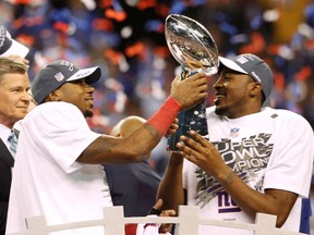 New York Giants Mario Manningham (left) and Hakeem Nicks hold the Vince Lombardi trophy after the Giants defeated the New England Patriots
 in  Super Bowl XLVI Sunday in Indianapolis. (REUTERS)
