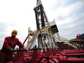 A worker performs a routine check on the valves at a natural gas appraisal well of Sinopec in Langzhong county, Sichuan province in this March 1, 2011 file photo. (REUTERS)