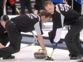 Sweepers Tim March (left) and Andrew Clayton of Mark Kean’s rink work the ice for the delivery of Patrick Janssen at the provincial men’s curling championship in Stratford, Ont., Feb. 7, 2012. At left, skip Jake Higgs urges on his sweepers. (SCOTT WISHART/QMI Agency)
