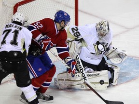 Penguins goaltender Marc-Andre Fleury makes a save against Canadiens forward Mathieu Darche at the Bell Centre in Montreal, Que., Feb. 7, 2012. (CHRISTINNE MUSCHI/Reuters)