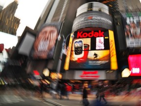People walk in front of a Kodak screen at Times Square in New York January 13, 2012. REUTERS/Eduardo Munoz