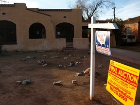 A realtor and bank-owned sign is displayed near a house for sale in Phoenix in this January 4, 2011 file photo. REUTERS/Joshua Lott/Files