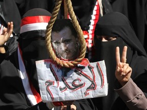 Women hold a picture of Syria's President Bashar al-Assad with a noose during a march to show solidarity with Syrian anti-government protesters and to call for Yemeni participation in the upcoming presidential election in Sanaa February 9, 2012. REUTERS/Mohamad Al Sayaghi