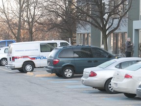 A police forensics identification van sits outside an apartment building at 560 Proudfoot Lane in London on Thursday Feb. 9, 2012 where police are investigating an overnight shooting.  Three males have been arrested after a woman was found shot to death.
(CRAIG GLOVER/QMI AGENCY)