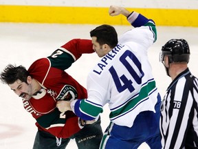 Canucks forward Maxim Lapierre fights with and Wild forward Cal Clutterbuck at the Xcel Energy Center in St. Paul, Minn, Feb. 9, 2012. (ERIC MILLER/Reuters)