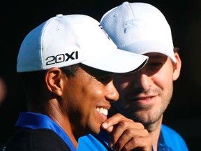 Tiger Woods talks with his playing partner, Cowboys quarterback Tony Romo, during the first round of the Pebble Beach National Pro-AM on Thursday, Feb. 9, 2012. (REUTERS/Robert Galbraith)