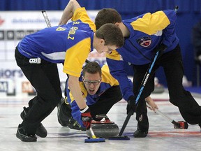 Alberta skip Brendan Bottcher throws a rock as sweepers Bryce Bucholz (left) and his twin brother Landon move in during their game against the Northwest Territories at Canadian junior curling championships in Napanee.