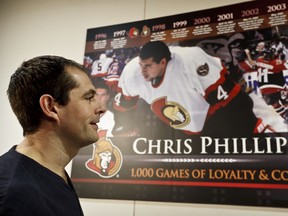 Chris Phillips gets a close look at a mural honouring his 1,000th career NHL game. (ERROL McGIHON/OTTAWA SUN)