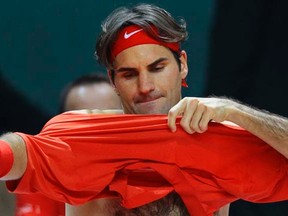 Switzerland's Roger Federer changes a shirt during his Davis Cup match against John Isner of the U.S. in Fribourg, Switzerland, on Friday, Feb. 10, 2012. (REUTERS/Michael Buholzer)