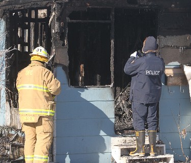 A fire investigator (l) and a member of the RCMP investigate a burned out trailer in Selkirk, Manitoba Saturday February 11, 2012 following an early morning fire that claimed four lives.
BRIAN DONOGH/WINNIPEG SUN/QMI AGENCY