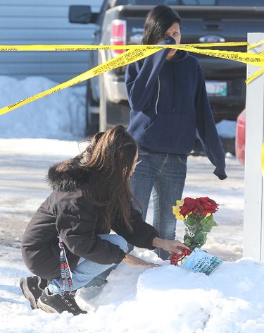 Raven O'Neil (r) wipes away a tear as Cheryl O'Neil,  places flowers at the scene of a fatal trailer fire in Selkirk, Manitoba Saturday February 11, 2012 that claimed four lives.
BRIAN DONOGH/WINNIPEG SUN/QMI AGENCY