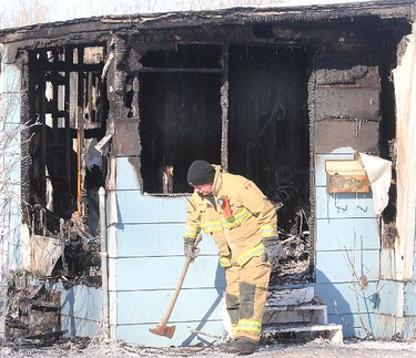 A fire investigator picks up an axe outside a burned out trailer in Selkirk, Manitoba Saturday February 11, 2012 following an early morning fire that claimed four lives.
BRIAN DONOGH/WINNIPEG SUN/QMI AGENCY
