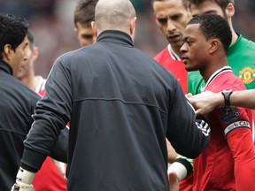 Manchester United's Patrice Evra (right) reacts after Liverpool's Luis Suarez (left) ignored his handshake before their match at Old Trafford on Saturday, Feb. 11, 2012. (REUTERS/Darren Staples)